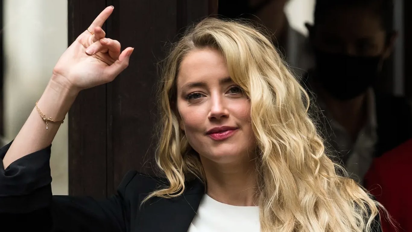 Amber-Heard-acenando Amber Heard está vivendo na Espanha sob pseudônimo de pistoleira, diz site