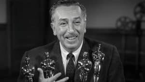 Walt Disney segurando estatuetas do Oscar